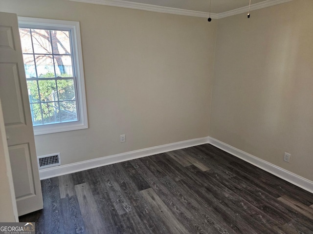 empty room featuring dark wood-type flooring and ornamental molding