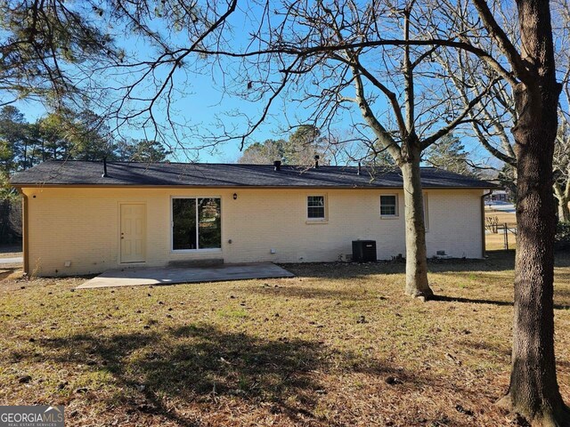 back of property with a patio, central AC, and a lawn