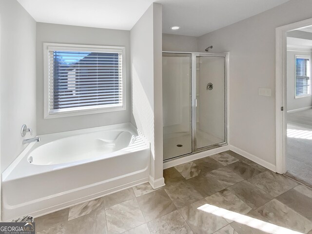 bathroom featuring shower with separate bathtub