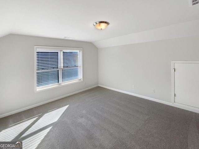 bonus room featuring dark colored carpet and vaulted ceiling