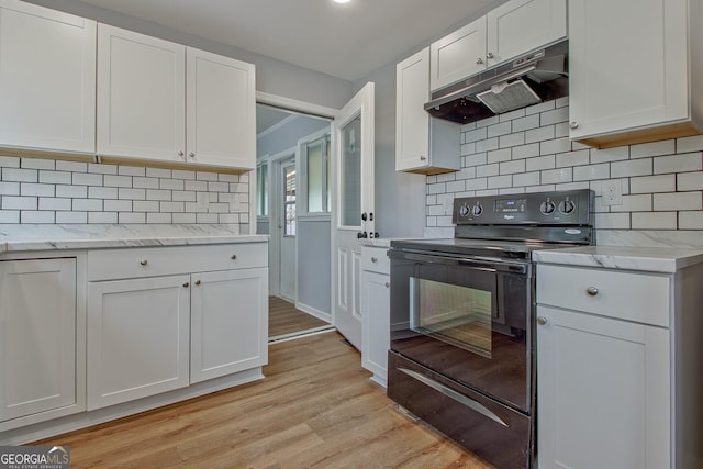 kitchen with light stone countertops, tasteful backsplash, white cabinets, light hardwood / wood-style floors, and black range with electric stovetop