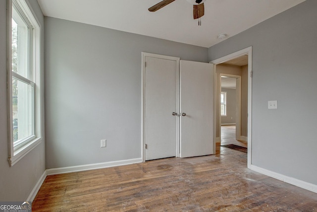 unfurnished bedroom with hardwood / wood-style floors, a closet, and ceiling fan