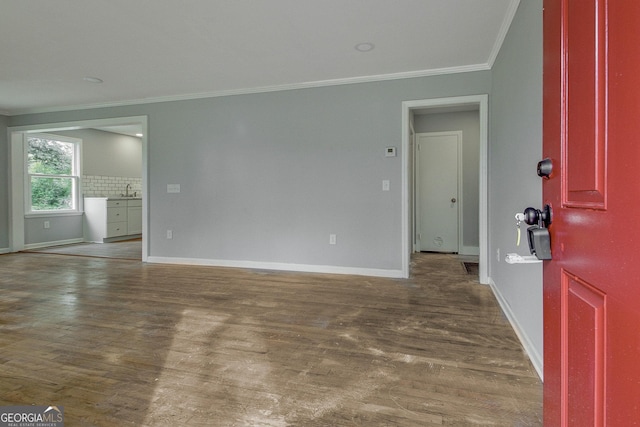 unfurnished room with dark hardwood / wood-style floors, sink, and crown molding