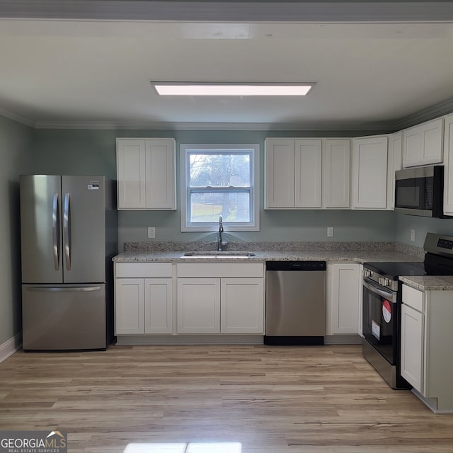 kitchen featuring white cabinets, light hardwood / wood-style floors, sink, and stainless steel appliances