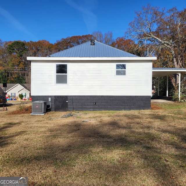 view of side of property featuring a yard, a carport, and cooling unit