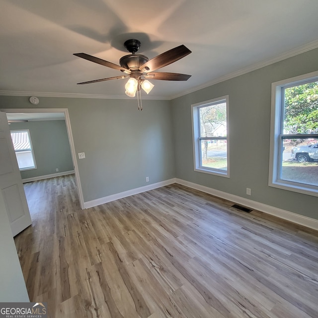 unfurnished room with crown molding, light hardwood / wood-style flooring, and a healthy amount of sunlight