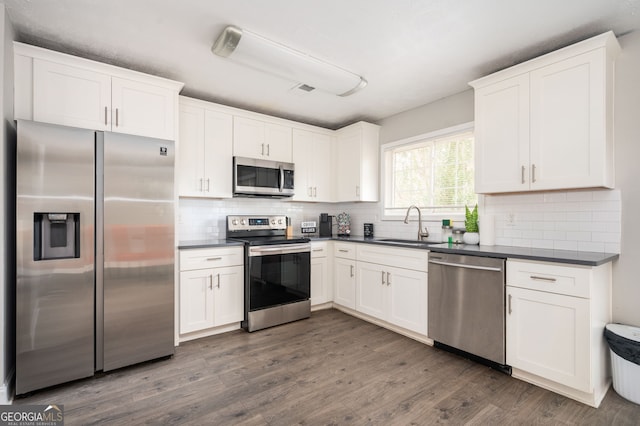 kitchen featuring sink, decorative backsplash, white cabinets, and appliances with stainless steel finishes