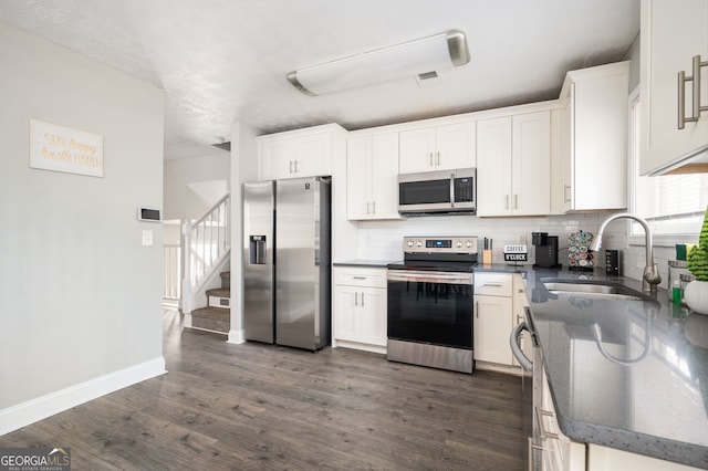 kitchen featuring dark hardwood / wood-style flooring, sink, stainless steel appliances, and white cabinets