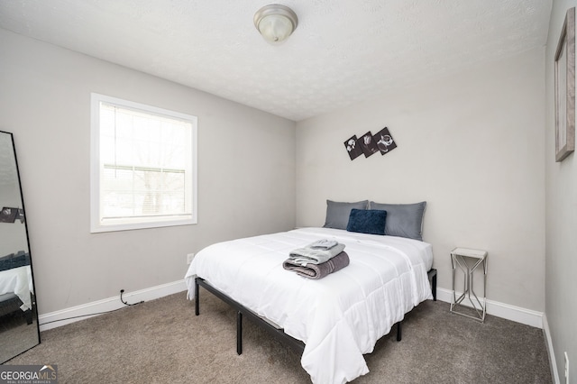 bedroom featuring a textured ceiling and dark carpet