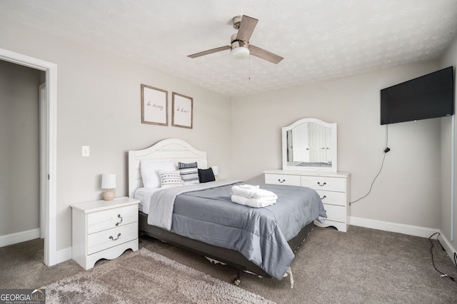 carpeted bedroom featuring ceiling fan and a textured ceiling