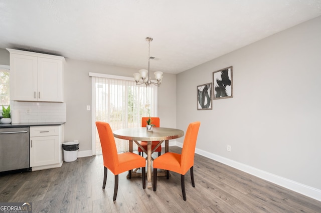 dining space featuring hardwood / wood-style flooring and a notable chandelier