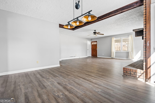 unfurnished living room with wood finished floors, baseboards, visible vents, ceiling fan, and a textured ceiling