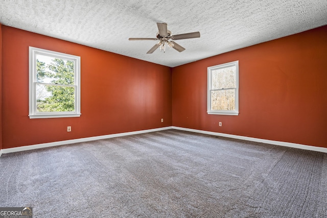 empty room featuring ceiling fan, carpet, baseboards, and a textured ceiling