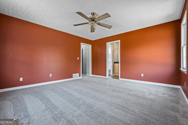 carpeted spare room with visible vents, baseboards, a textured ceiling, and ceiling fan