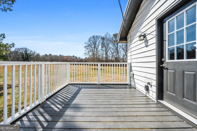 wooden deck featuring a lawn