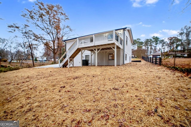 rear view of property featuring central AC and a wooden deck