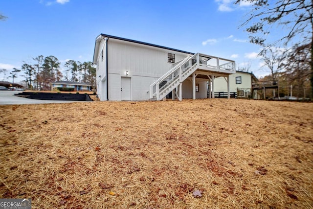 rear view of property with a garage and a deck