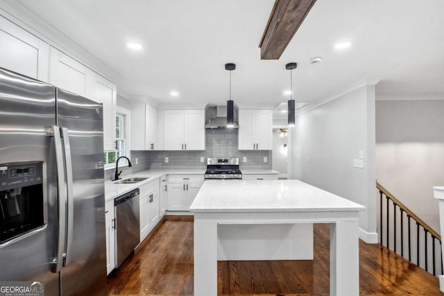 kitchen featuring stainless steel appliances, dark wood-type flooring, sink, wall chimney range hood, and hanging light fixtures