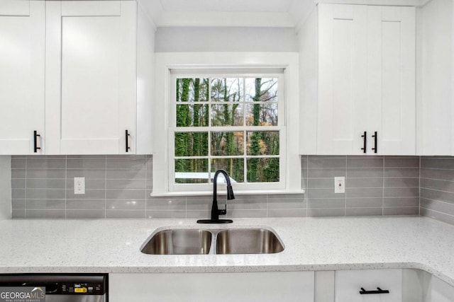 kitchen featuring light stone countertops, sink, and white cabinets