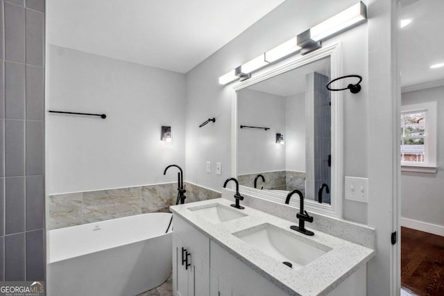 bathroom with vanity, hardwood / wood-style flooring, and a bathtub