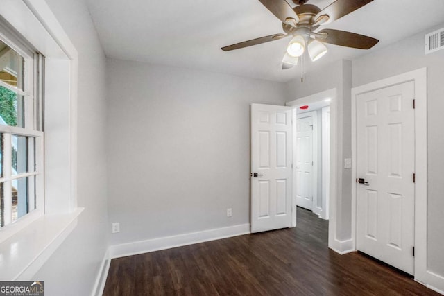 unfurnished bedroom featuring dark hardwood / wood-style floors and ceiling fan