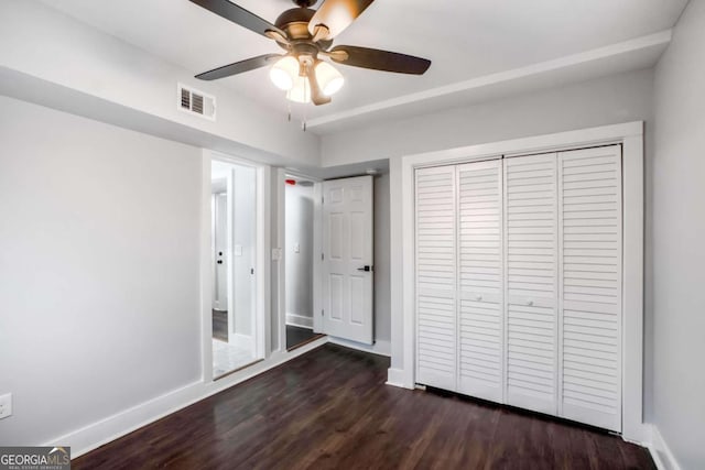 unfurnished bedroom featuring dark hardwood / wood-style flooring, a closet, and ceiling fan