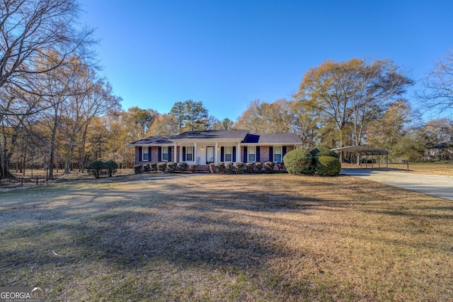 ranch-style home featuring a front lawn, covered porch, and a carport