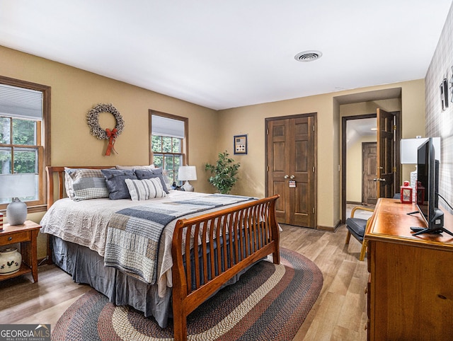 bedroom featuring light wood-type flooring and visible vents