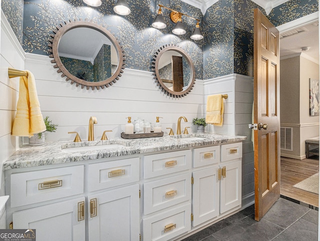 full bath with wainscoting, a sink, and wallpapered walls