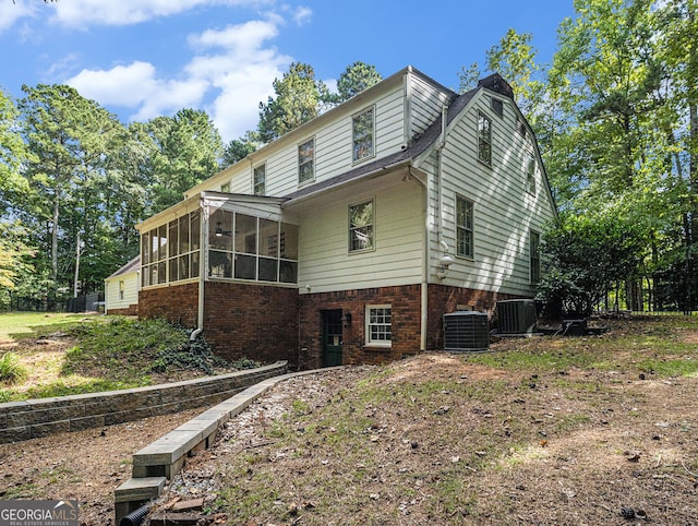 view of property exterior with central air condition unit and a sunroom