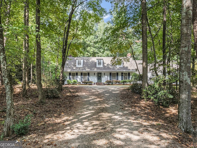 new england style home with covered porch and driveway