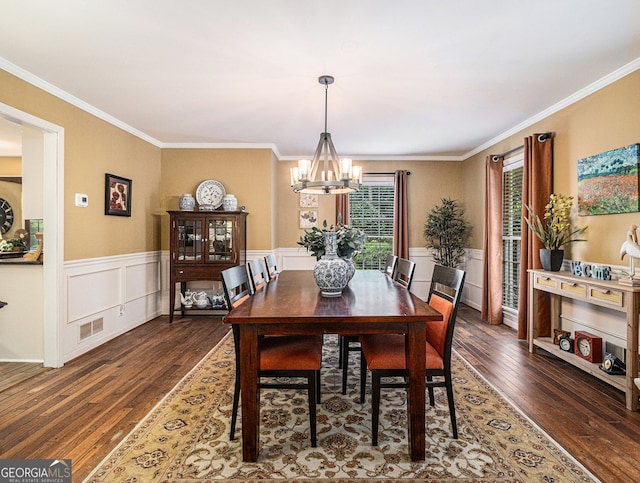 dining room with a chandelier, a wainscoted wall, crown molding, and hardwood / wood-style floors