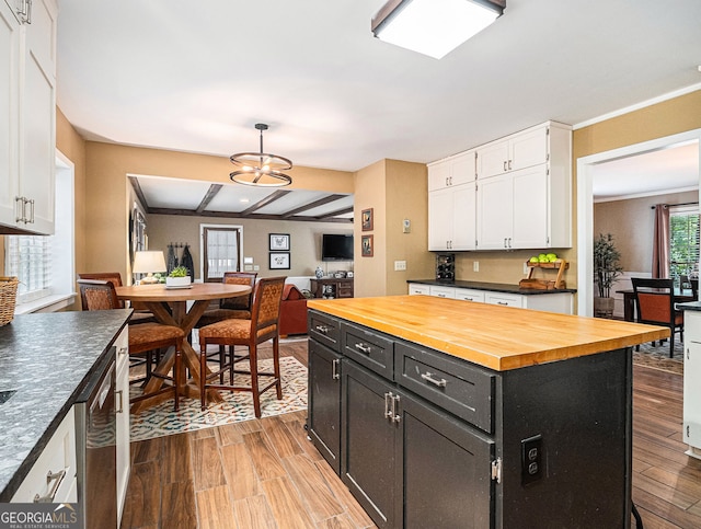 kitchen with white cabinets, dishwasher, wood counters, wood finished floors, and dark cabinetry