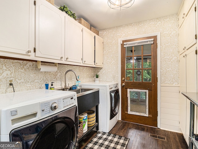 washroom featuring visible vents, separate washer and dryer, cabinet space, and wallpapered walls