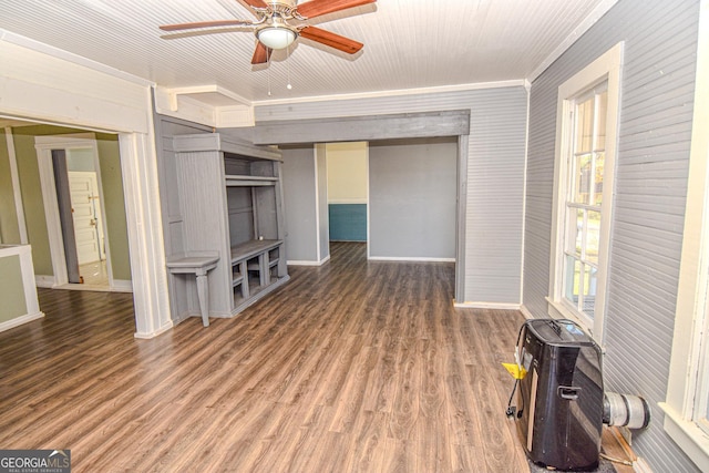 unfurnished living room featuring ornamental molding, ceiling fan, and dark wood-type flooring