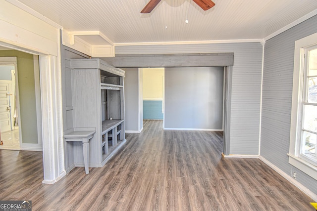 unfurnished living room featuring crown molding, ceiling fan, and dark wood-type flooring