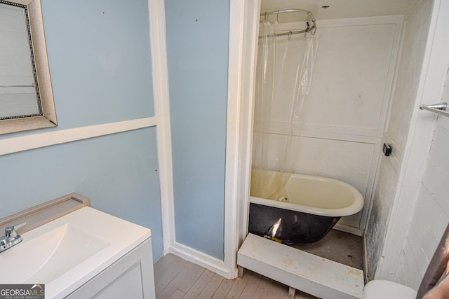 bathroom featuring vanity, plus walk in shower, and wood-type flooring