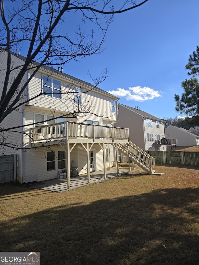 back of property with a lawn, a patio area, and a wooden deck