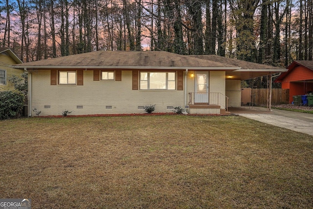 ranch-style home featuring a carport and a lawn