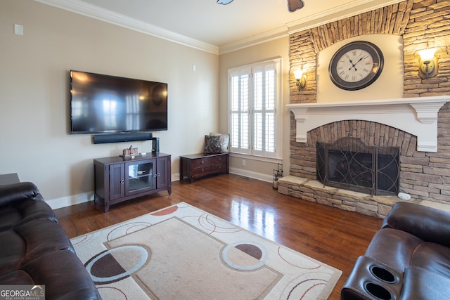 living room featuring dark wood-type flooring, ornamental molding, and a stone fireplace