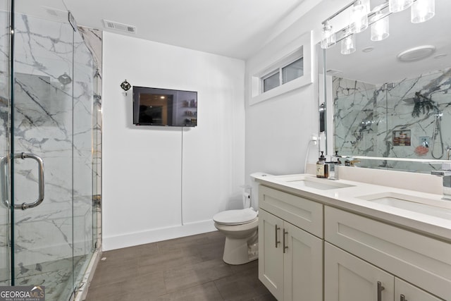 bathroom featuring vanity, toilet, and a shower with door