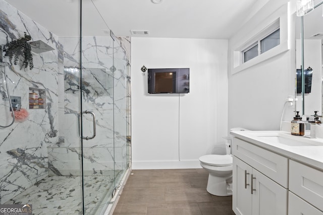 bathroom featuring an enclosed shower, vanity, and toilet