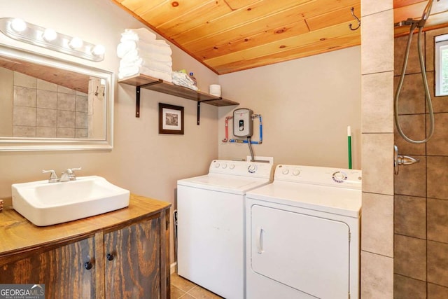 clothes washing area with washing machine and dryer, sink, light tile patterned flooring, and wood ceiling