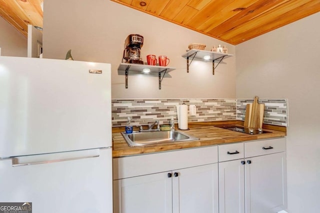 kitchen featuring sink, wooden ceiling, white fridge, lofted ceiling, and white cabinets