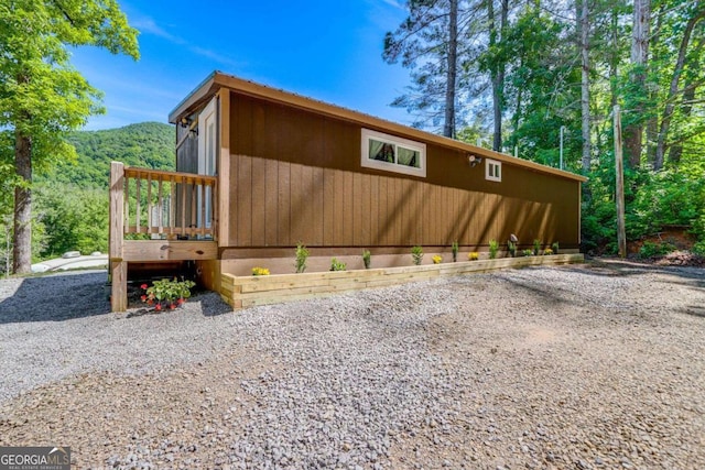 view of side of property featuring a deck with mountain view