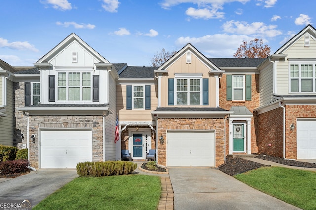 multi unit property with an attached garage, stone siding, board and batten siding, and concrete driveway