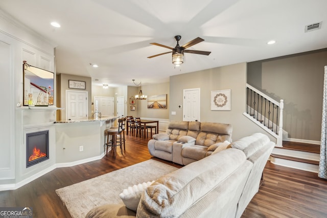 living area with dark wood-type flooring, recessed lighting, visible vents, and stairway