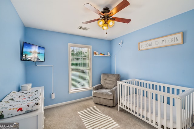 bedroom featuring a crib, carpet, visible vents, and baseboards