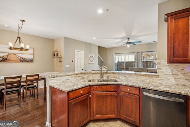 kitchen with dishwasher, a peninsula, a sink, and light stone countertops