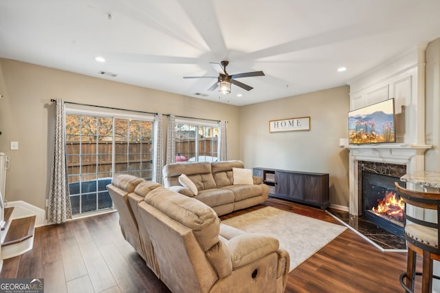 living area with dark wood finished floors, visible vents, a fireplace, and recessed lighting